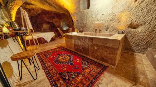 a bathroom with a sink and a rug at crassula cave kapadokya hotel in Nar