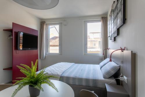 een slaapkamer met een bed en een potplant bij Residenza SubitoSanto - Appartamento 5B "Giotto" in Padua