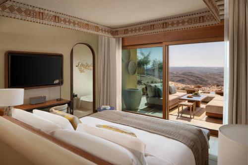 a bedroom with a bed and a view of the desert at Six Senses Southern Dunes, The Red Sea in Khuff