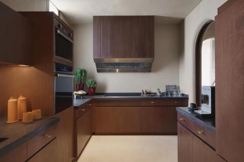 a large kitchen with wooden cabinets and a sink at Six Senses Southern Dunes, The Red Sea in Khuff