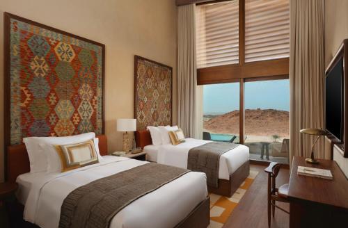a hotel room with two beds and a window at Six Senses Southern Dunes, The Red Sea in Khuff