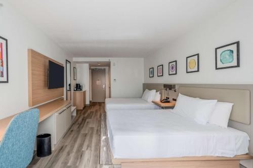 a hotel room with two beds and a television at Hilton Garden Inn Ft. Lauderdale Airport-Cruise Port in Dania Beach
