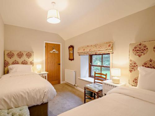 a bedroom with two beds and a window at 3 Bed in Lockerbie 89759 in Ecclefechan
