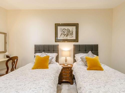 two beds in a bedroom with yellow pillows at 2 Bed in Rowlands Gill 89758 in Stanley
