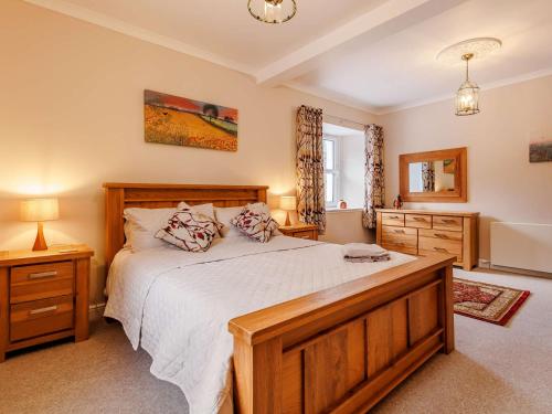 ein Schlafzimmer mit einem großen Holzbett und einem Fenster in der Unterkunft 4 Bed in Pitlochry 89750 in Tummel Bridge