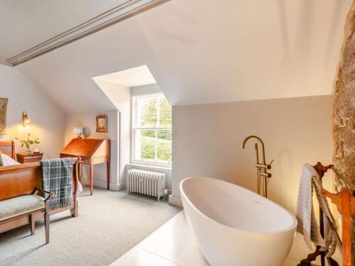 a bathroom with a tub and a bedroom with a piano at 3 Bed in Cairngorms 89718 in Inverurie