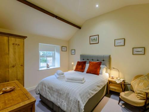 um quarto com uma cama grande e uma cadeira em 3 Bed in Leyburn 89746 em Spennithorne