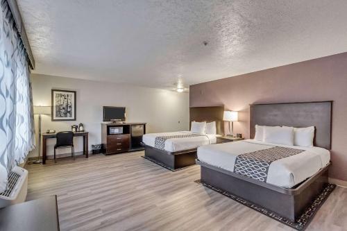 a hotel room with two beds and a desk at La Quinta by Wyndham North Orem in Orem