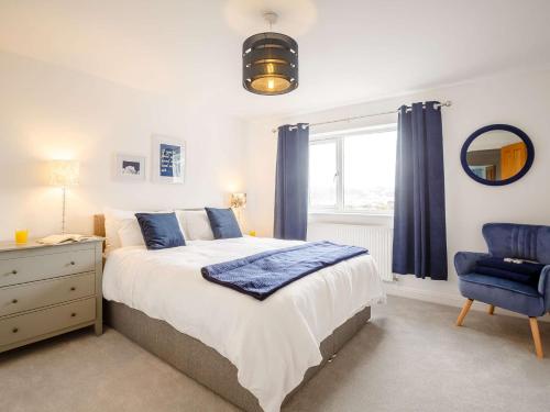 a bedroom with a bed and a blue chair at 4 Bed in Llandudno 89703 in Deganwy