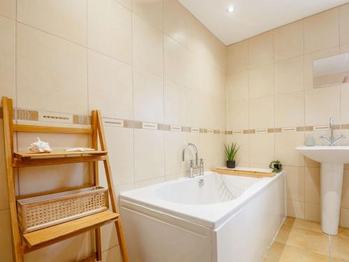 uma casa de banho com uma banheira grande e um lavatório em 4 Bed in Llandudno 89703 em Deganwy
