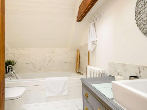 a white bathroom with a tub and a sink at 3 Bed in Pulham St Mary 89618 in Pulham