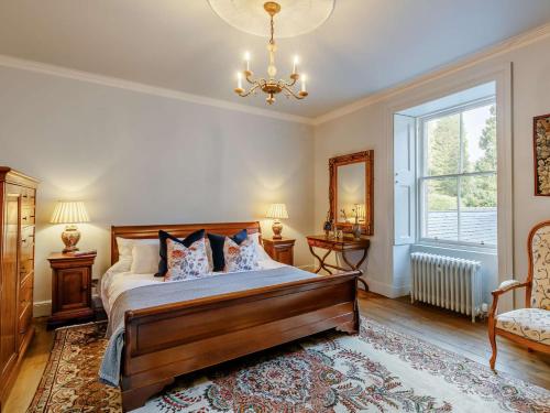 a bedroom with a bed and a window and a chandelier at 2 Bed in Cairngorms 89717 in Inverurie