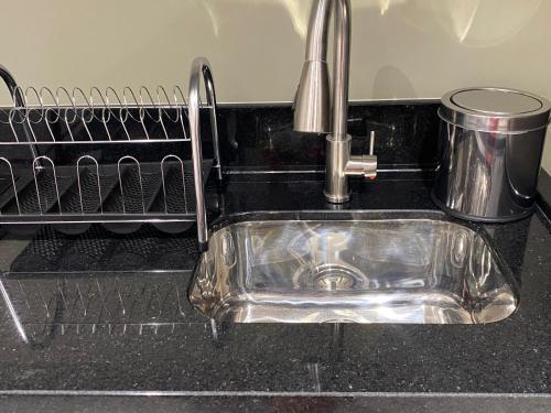 a kitchen sink with a faucet on a counter at Flat 205 Homebusiness perto do centro! in Pomerode