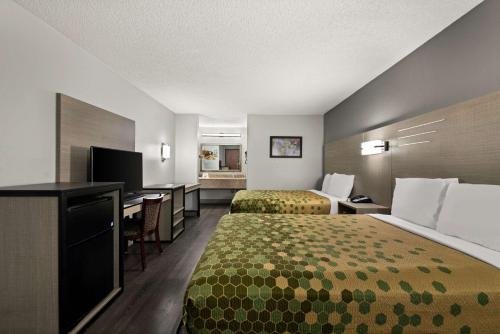 a hotel room with two beds and a desk at Econo Lodge in Richmond
