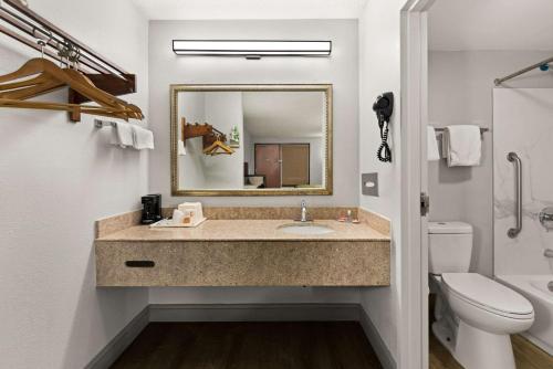 a bathroom with a sink and a mirror at Econo Lodge in Richmond
