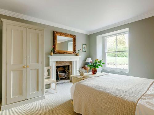 a bedroom with a bed and a mirror and a fireplace at 2 Bed in Cairngorms 89716 in Inverurie