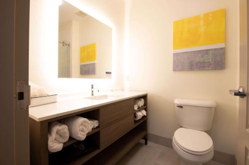 W łazience znajduje się toaleta, umywalka i lustro. w obiekcie Comfort Suites Oil Center w mieście Lafayette
