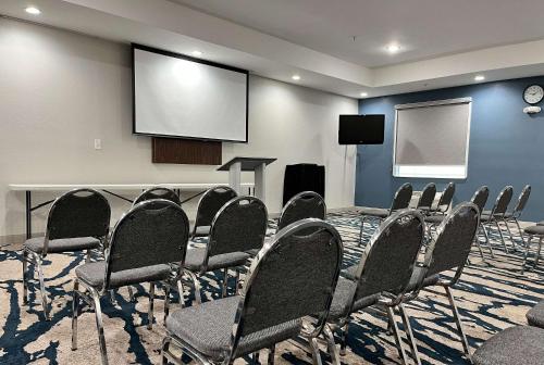 a conference room with chairs and a screen at Comfort Suites Oil Center in Lafayette