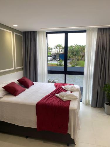 a bedroom with a large bed and a large window at Flat 205 Homebusiness perto do centro! in Pomerode