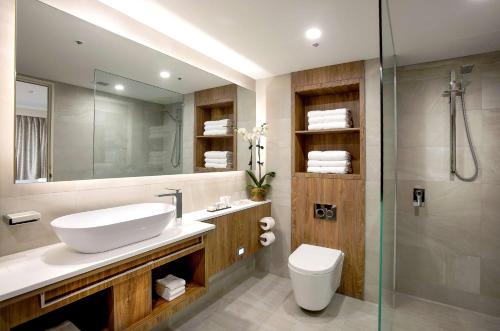 a bathroom with a sink and a toilet and a shower at Rydges South Bank Brisbane in Brisbane