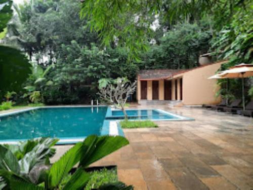 une piscine au milieu d'un jardin dans l'établissement Raindrops Resorts Wayanad Kerala, à Sultan Bathery