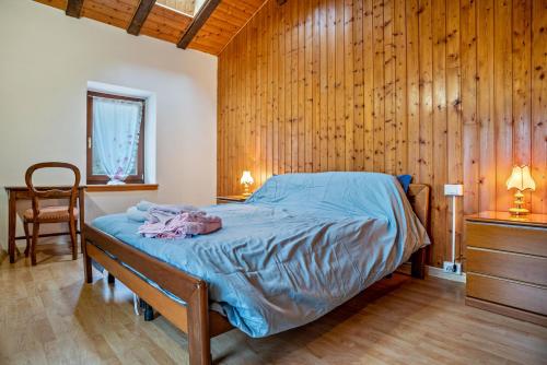 een slaapkamer met een bed met een houten muur bij Beb chalet bella vita Trento in Vignola