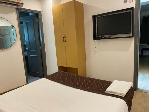 a small room with a bed and a flat screen tv at Qotel Comfort IP Residency East Delhi Preet Vihar in New Delhi