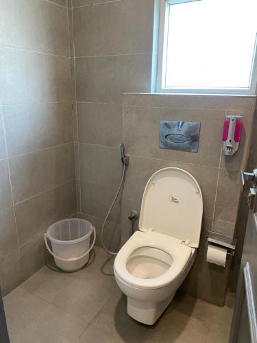 a small bathroom with a toilet and a window at Qotel Comfort IP Residency East Delhi Preet Vihar in New Delhi