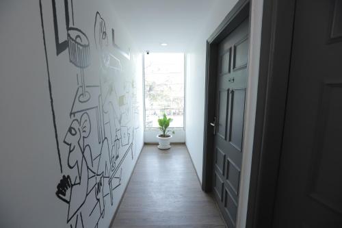 a hallway with graffiti on the walls and a door at Qotel Comfort IP Residency East Delhi Preet Vihar in New Delhi