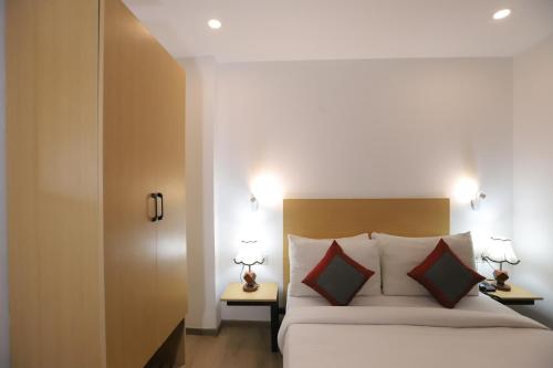 a bedroom with a bed with two tables and two lamps at Qotel Comfort IP Residency East Delhi Preet Vihar in New Delhi
