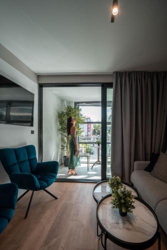 a woman is standing in a living room at Athesense Suites in Athens