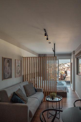 a living room with a couch and a bed at Athesense Suites in Athens