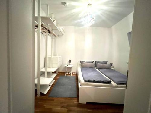 a bedroom with a white bed and a white shelf at Gemütliche Wohnung im Zentrum. in Bayreuth