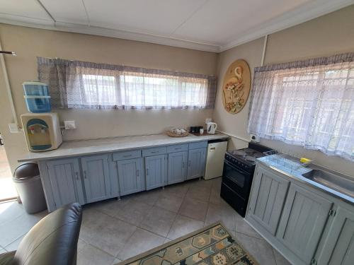 cocina con armarios azules y encimera en Feather Rest en Bloemfontein