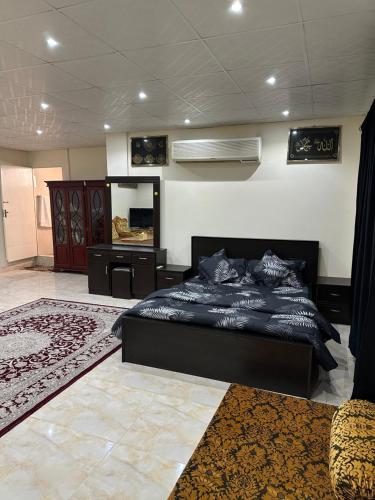 a bedroom with a black bed and a mirror at Al Ramla, Na’eem Bin Masoud St#8, Villa#10 in Sharjah
