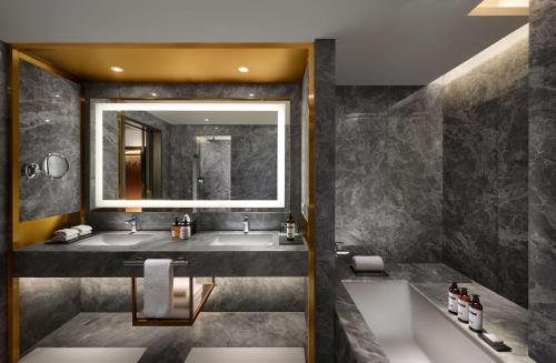 a bathroom with two sinks and a large mirror at Hyatt Regency Jaipur Mansarovar in Jaipur