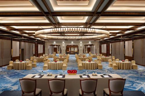 a large room with tables and chairs and a large chandelier at Hyatt Regency Jaipur Mansarovar in Jaipur