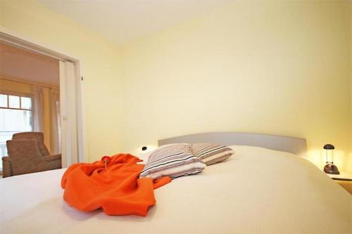 キュールングスボルンにあるStrandschloesschen-Haus-II-WE-13-9889の白いベッド(オレンジのタオル付)