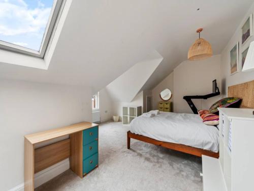 sypialnia z łóżkiem i biurkiem na poddaszu w obiekcie Pass the Keys Modern and luxury London house w Londynie