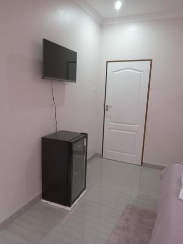 a living room with a television and a door at Chaya accommodation B&B and self catering in Mzuzu