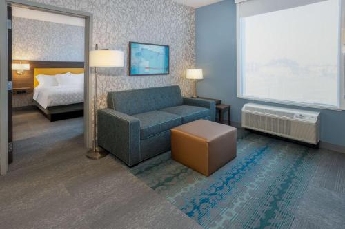 a hotel room with a couch and a bed at Tru By Hilton Pensacola Airport Medical Center in Pensacola