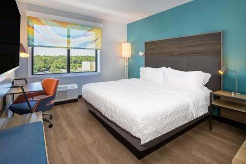 a hotel room with a bed and a desk and a chair at Tru By Hilton Pensacola Airport Medical Center in Pensacola