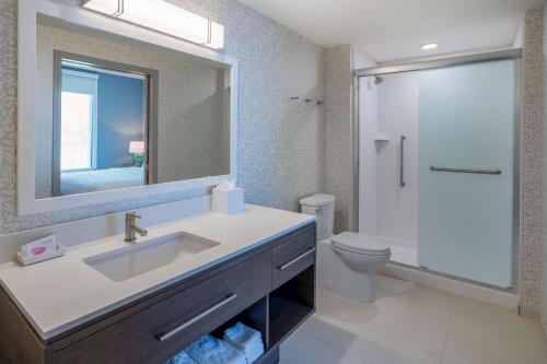 a bathroom with a sink and a toilet and a mirror at Tru By Hilton Pensacola Airport Medical Center in Pensacola