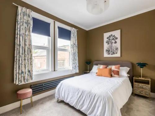 1 dormitorio con 1 cama grande y 2 ventanas en Pass the Keys Welcoming terrace with free street parking en Bath