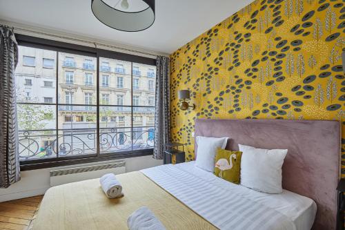 une chambre avec un lit et une grande fenêtre dans l'établissement Residence Centre de Paris by Studio prestige, à Paris