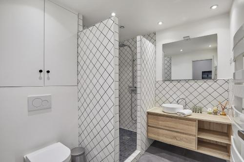 une salle de bain avec toilettes, lavabo et miroir dans l'établissement Residence Centre de Paris by Studio prestige, à Paris