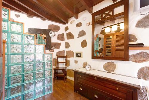 a bathroom with a stone wall and a mirror at Bentayga Sensation in El Chorrillo