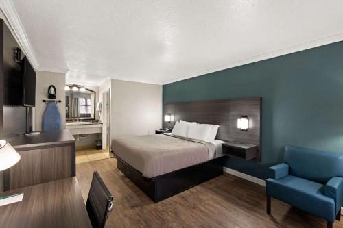 Quality Inn في أوشن سبرينغز: غرفة فندق بسرير وجدار ازرق