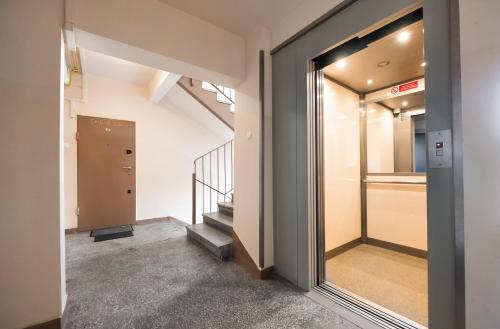 a hallway with a glass door and stairs in a building at Metro Targówek Comfy Apartment in Warsaw