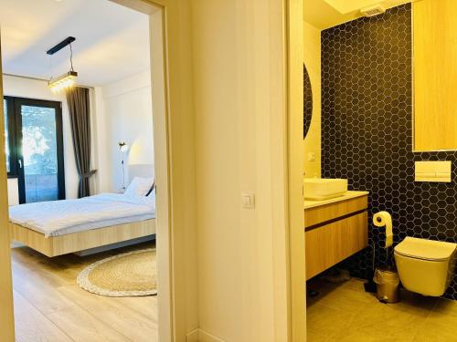 a bedroom with a bed and a bathroom with a sink at Ski Retreat in Poiana Brasov